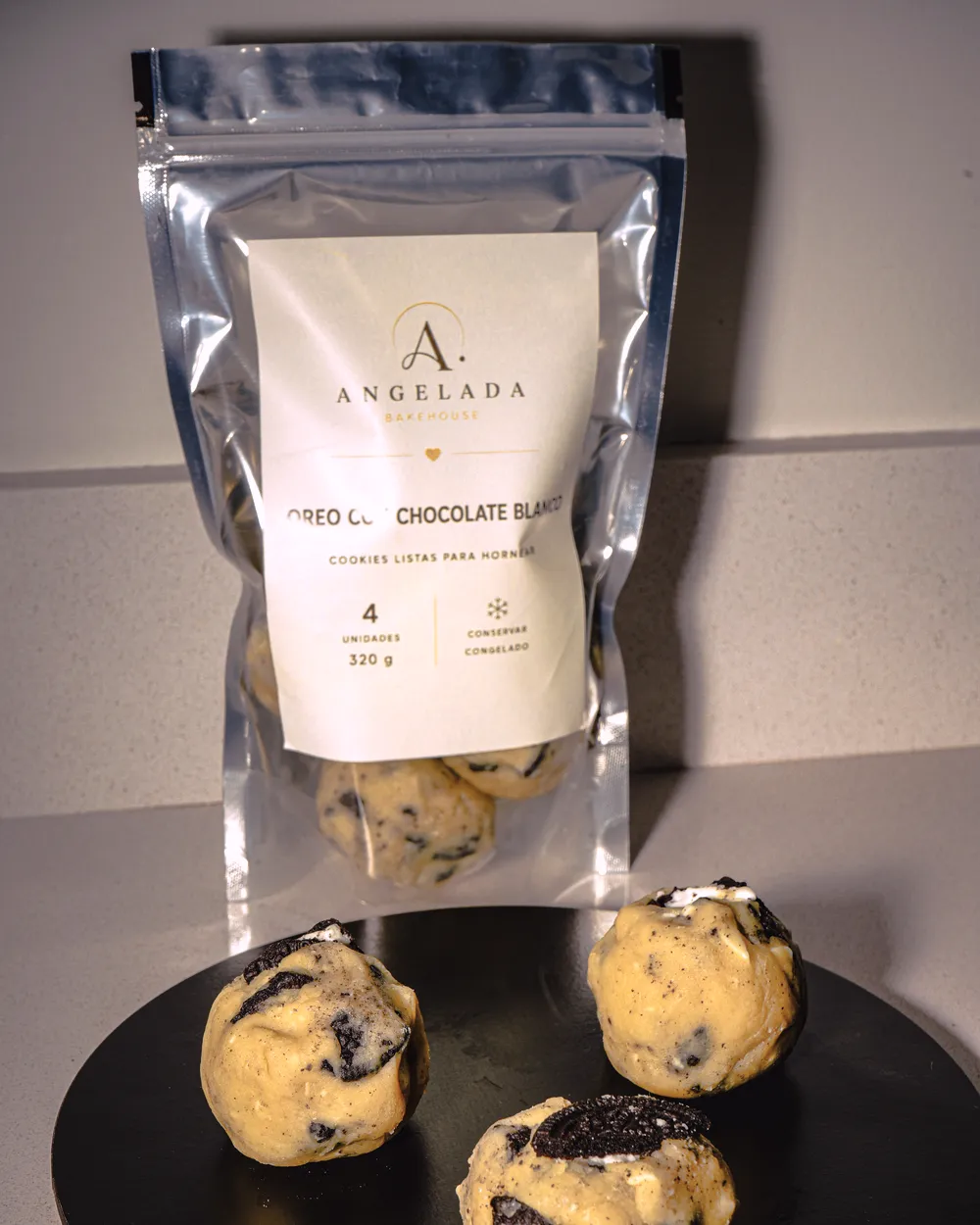 Bolsa de Oreo con Chocolate Blanco de cerca, con las bolitas de masa congelada sobre un plato negro