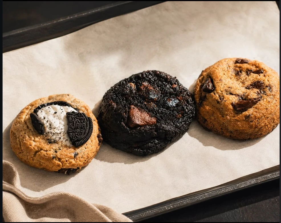 Tres cookies recién horneadas sobre papel manteca